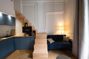 a living room with a blue couch and a kitchen at Le Chavannes -Ecrin élégant & Cosy - Pentes de la Croix Rousse in Lyon
