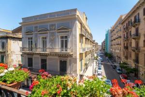 un edificio de apartamentos en una calle de la ciudad con flores en Ballaro' Hotel - Budget Room, en Palermo