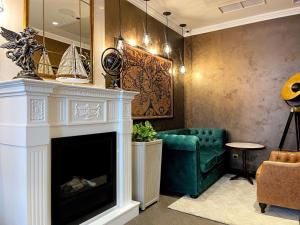 a living room with a fireplace and a green couch at Best Western Plus Market Square Lviv in Lviv