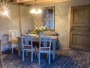 einem blauen Esstisch mit Stühlen und einer Vase aus Blumen in der Unterkunft Gut Kalkhäuschen, ein Ort mit Geschichte in Aachen