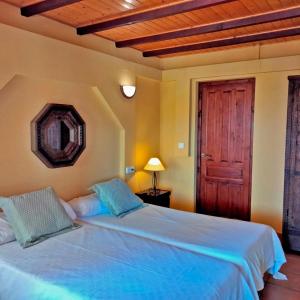 a bedroom with a blue bed with a wooden ceiling at Hostal León Dormido in Polop