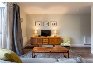 a living room with a tv and a coffee table at ALTIDO Chic flat with balcony in Merchant City in Glasgow