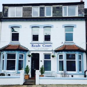 un edificio blanco con un letrero de registro en él en Reads Court Holiday Apartments - Blackpool Resort Collection en Blackpool