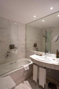 y baño con lavabo, bañera y ducha. en Parador de Bielsa, en Espierba