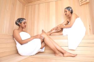 Dos mujeres están sentadas en una sauna. en TH BonRoyal Hotel, en Addis Ababa