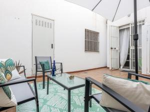 uma sala de estar com uma mesa de vidro e cadeiras em La muralla de Sevilla em Sevilha