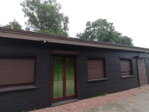 a black brick house with windows on a street at MK Hostel Bremen in Bremen