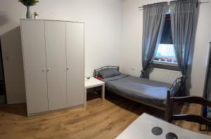 Dormitorio pequeño con cama, armario y ventana en MK Hostel Bremen, en Bremen
