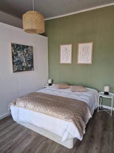 a bedroom with a large bed and two pictures on the wall at Hospedaria Pôr do Sol in Funchal