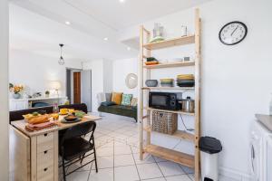 a kitchen and a living room with a table and a room with a kitchen at Le Clos des Rosiers in Toulouse