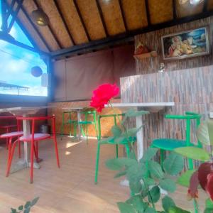 un restaurante con mesas y sillas coloridas y una flor roja en Zelobi Venture en Kintamani
