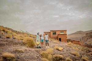 a group of three people standing on top of a hill at Ouednoujoum Ecolodge & Spa in Ouarzazate