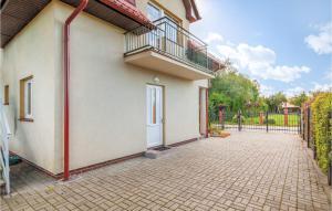 ein Gebäude mit einem Balkon und einer Backsteineinfahrt in der Unterkunft Cozy Apartment In Rowy With Kitchen in Rowy