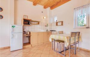 a kitchen with a table and a refrigerator at Stunning Apartment In Rowy With 1 Bedrooms in Rowy