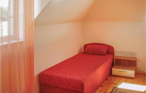 ロビにあるCozy Apartment In Rowy With Kitchenの赤いベッドと窓付きの小さなベッドルーム1室が備わります。