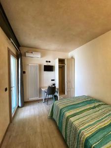 VidorにあるLocazione Turistica El Sghirloのベッドとデスクが備わるホテルルームです。