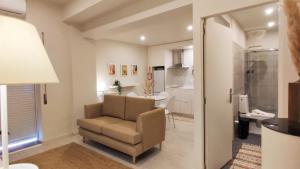 a living room with a chair and a bathroom at Naty Studio with Terrace in Vila Nova de Famalicão