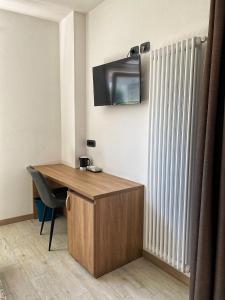 Zimmer mit einem Schreibtisch und einem TV an der Wand in der Unterkunft Locazione Turistica El Sghirlo in Vidor