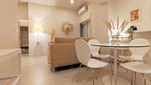 - un salon avec une table, des chaises et un canapé dans l'établissement Naty Studio with Terrace, à Vila Nova de Famalicão