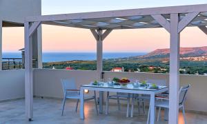 una mesa y sillas en un balcón con vistas en Villa Di Giorgio Heated Pool en Kournás