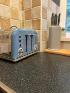 a blue toaster sitting on a counter in a kitchen at CWTCH COTTAGE Llantrisant 2 bed home - sleeps 4 in Llantrisant