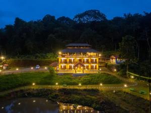 un grande edificio di notte con uno stagno di The Hosteller Coorg Rainforest, Madikeri a Madikeri