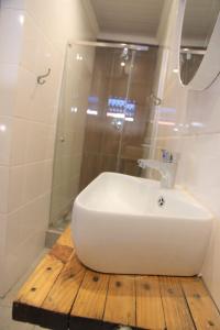 y baño con lavabo blanco y ducha. en Nini's guest units en Bloemfontein