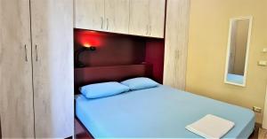 ein kleines Schlafzimmer mit einem Bett und einem Schrank in der Unterkunft 2V1 - Blloku MAC in Tirana