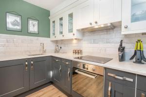 a kitchen with gray cabinets and white appliances at 8 Blue Bridge- Elegant and Luxurious 1 Bedroom Apt- Free Parking in York +14 photos