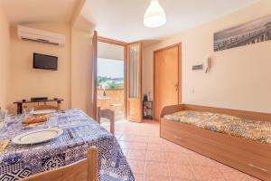 una camera con letto, tavolo e TV di San Carlo - private beach a Palermo