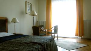 a bedroom with a bed and a large window at Flatneartocastlehill in Budapest