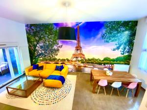 uma sala de estar com um mural da Torre Eiffel em Magnifique VILLA avec jacuzzi au pied du STADE em Saint-Denis