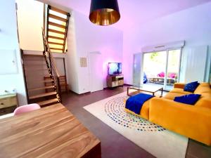 uma sala de estar com uma cama amarela e uma escada em Magnifique VILLA avec jacuzzi au pied du STADE em Saint-Denis