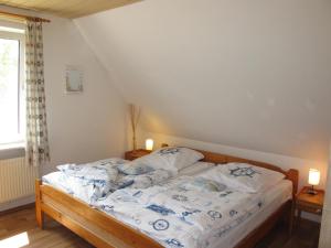 1 dormitorio con 1 cama con sábanas azules y blancas en FeWo ONNO NORD151, en Norden