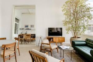 a living room with a green couch and a table at A Gorgeous Studio in the Hippest Building in Town in Tel Aviv