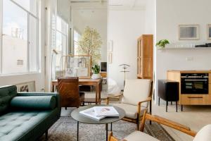 ein Wohnzimmer mit einem Sofa und einem Tisch in der Unterkunft A Gorgeous Studio in the Hippest Building in Town in Tel Aviv