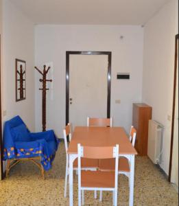 um quarto com uma mesa e cadeiras e um sofá azul em Appartamento 6 em Ameglia
