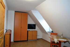 a living room with a dining table and a cabinet at Pension-Gästehaus Oberscheven Leipziger Neuseenland in Kitzscher