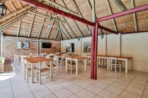 St Lucia的住宿－St Lucia Safari Lodge Holiday Home，一间设有桌椅的用餐室和砖墙