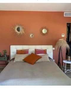 a bed with orange walls and two mirrors above it at Chambre à Louer sur bonifacio in Bonifacio