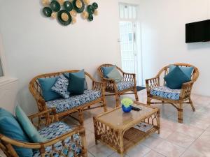 a living room with wicker chairs and a table at Camelia 2 Flic en Flac Mauritius in Flic-en-Flac