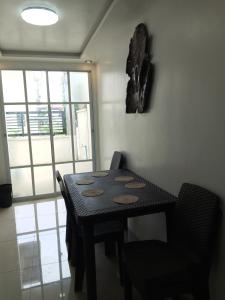 Oton的住宿－Budget Home in Iloilo Staycation At 8 Pax，窗户客房内的一张黑桌子和椅子