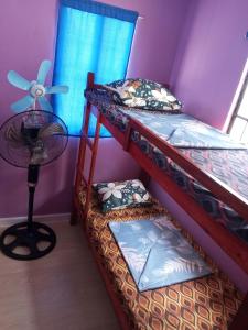 two bunk beds in a room with a fan at Budget Home in Iloilo Staycation At 8 Pax in Oton