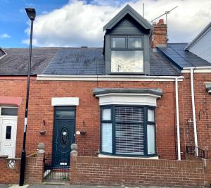 une maison en briques avec une fenêtre et une porte noire dans l'établissement High Barnes 3 Bed House with Parking, Sleeps 7, Quiet Location, à Sunderland