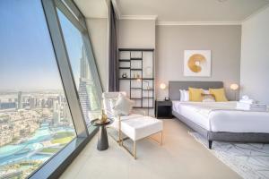 ein Schlafzimmer mit einem Bett und einem großen Fenster in der Unterkunft Burj Vista, Downtown Dubai - Burj Khalifa View - Mint Stay in Dubai
