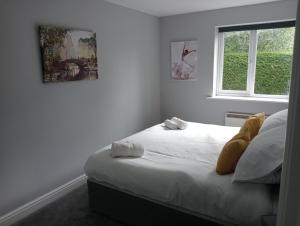 a bedroom with a bed with white sheets and a window at Green Street Retreat in York