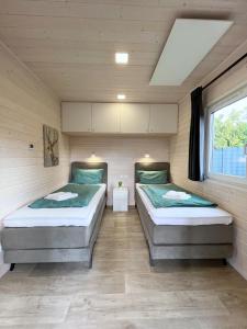 2 camas individuales en una habitación con ventana en Naturhaus Meerjungfrau mit Boxspringbetten in ruhiger Lage von Steinhude, en Steinhude