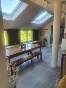 d'une salle à manger avec une table en bois et des lucarnes. dans l'établissement Les grives aux loups, à Brive-la-Gaillarde