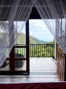 an open door to a balcony with a view at adam's apple homestay in Ella