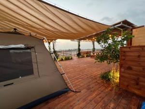 a tent on top of a deck with a wooden floor at Atlit Rooftop Glamping in Atlit